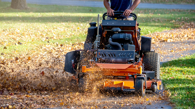 A man using a mulching mower to mulch leaves