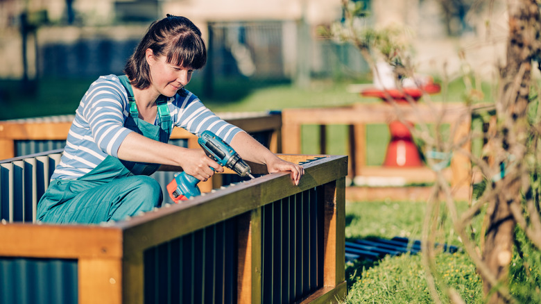 A woman building a raised garden bed