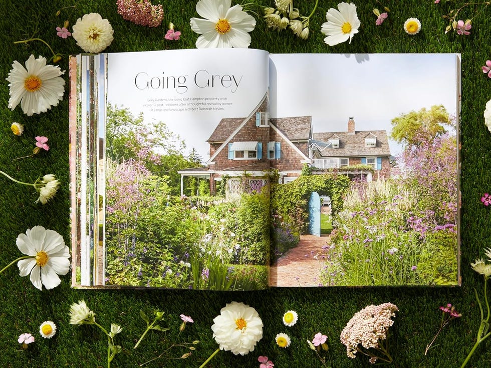 open book showcasing the grounds of gray gardens estate in new york, with a garden, shingle style house with blue shutters, and lush flowers bordering a path