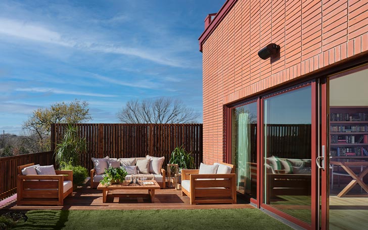 A top-floor room of a home opens out to a grassy terrace