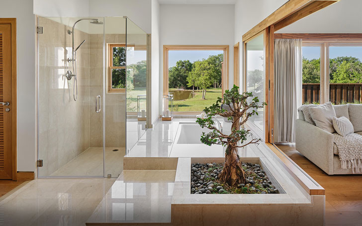 An open concept bathroom that looks out into a grassy field