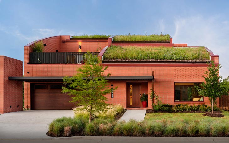 A red brick home with a grass roof in the Tapestry development in Frisco, Texas 