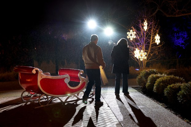 A couple passes by a sleigh at the Christmas at...