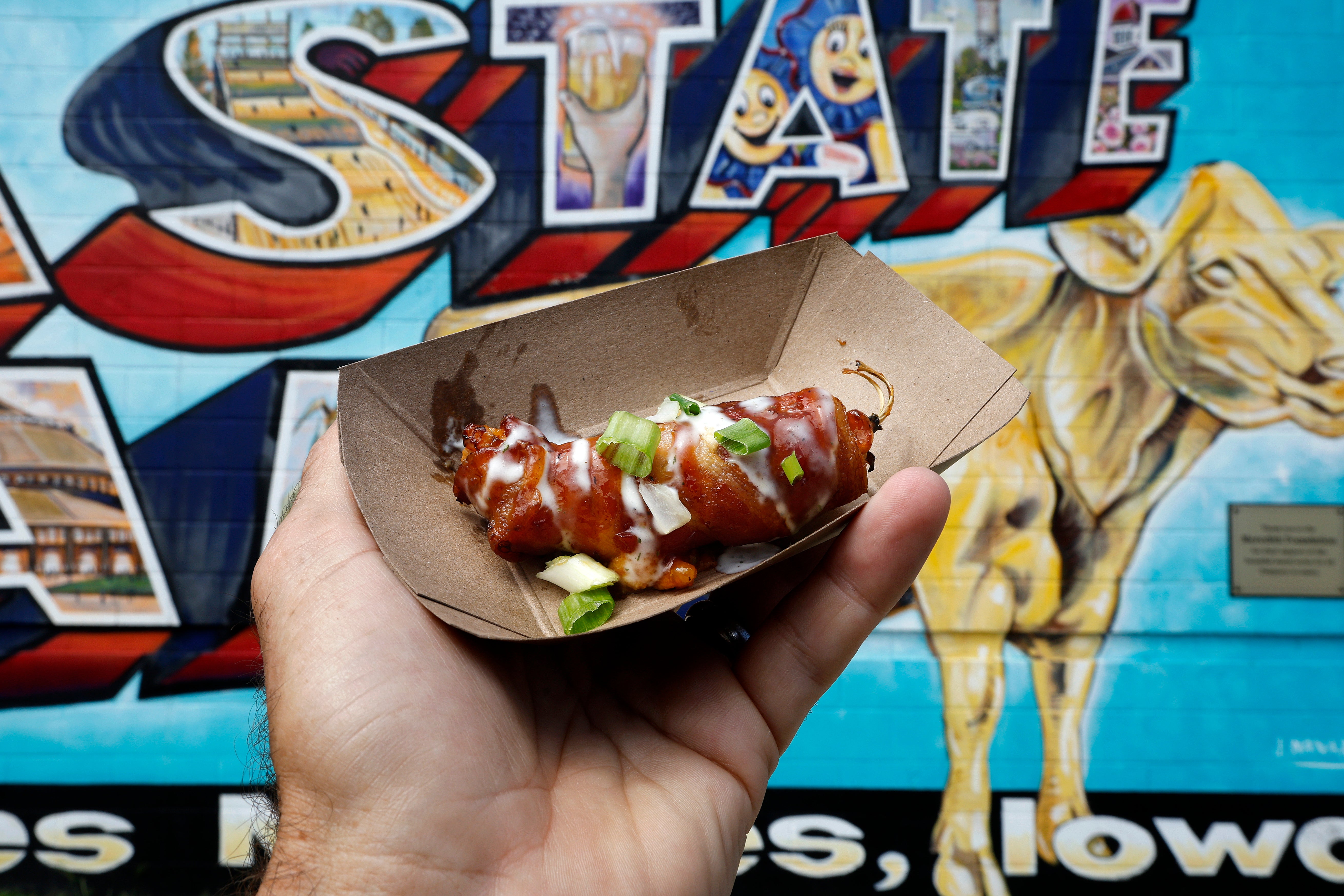 A man holds an ‘Iowa Twinkie’ dish topped with a sprinkle of chives in Des Moines, Iowa, in August 2023. Chives are found at most grocery stores across the U.S.