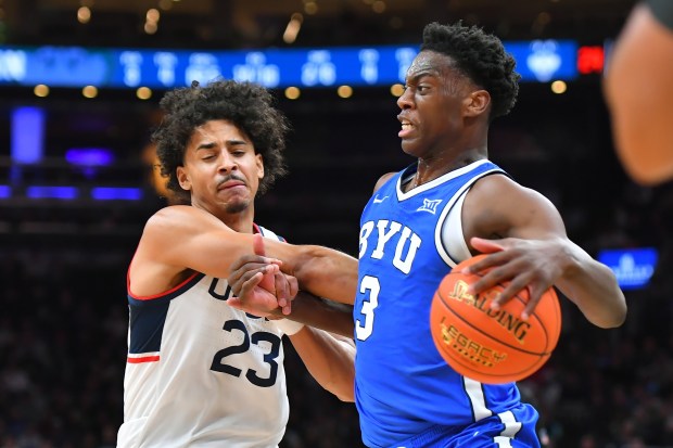 BYU forward AJ Dybantsa (3) drives toward the basket as UConn forward Jayden Ross (23) defends in the first half of an NCAA college basketball game, Saturday, Nov. 15, 2025, in Boston. (AP Photo/Steven Senne)