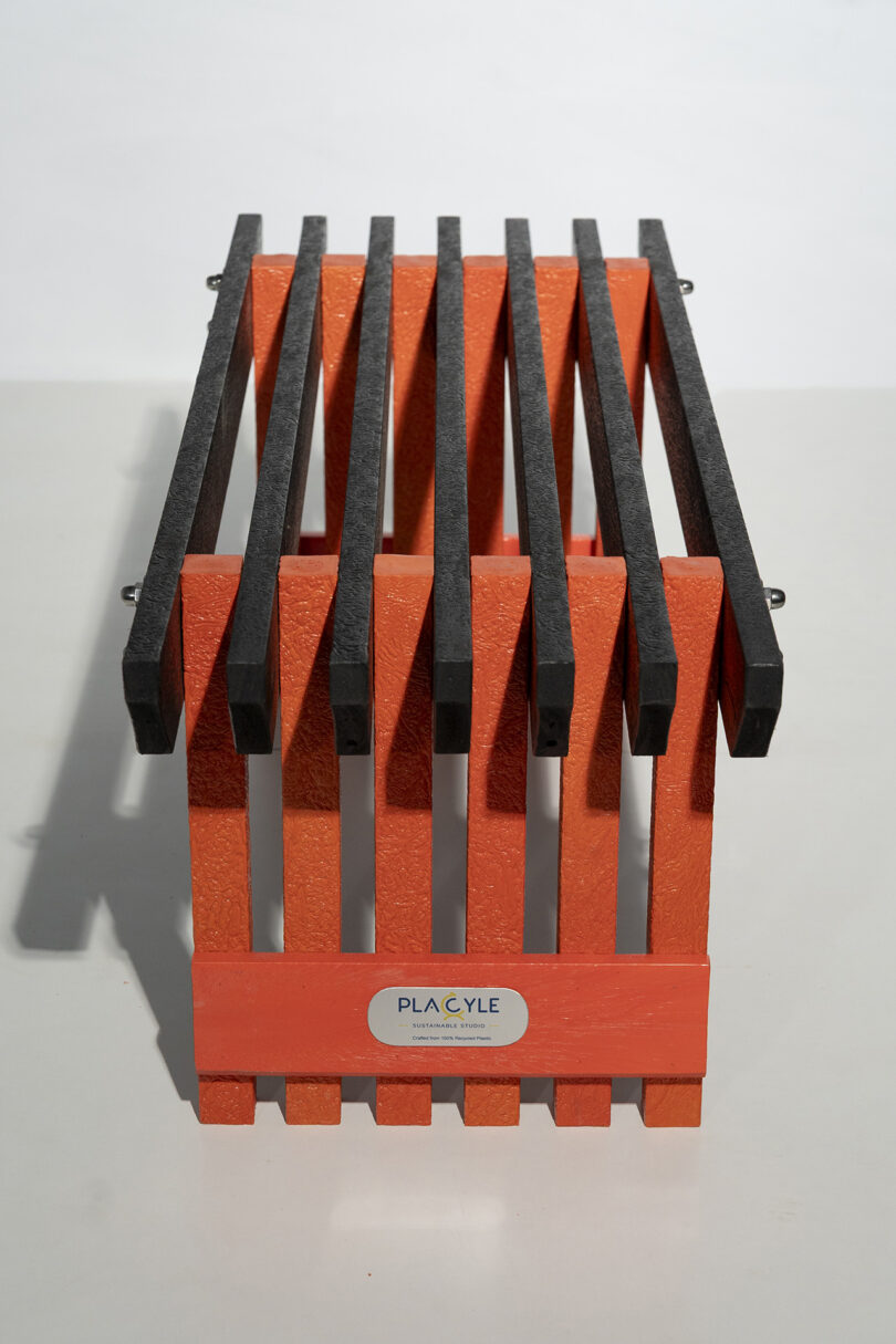 An orange and black rectangular object with vertical and horizontal bars, labeled "PLACYLE" on the front, placed on a light surface.