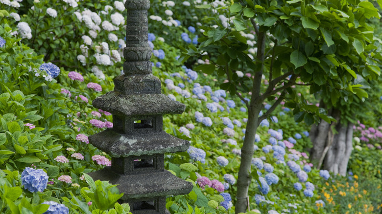 A pagoda sculpture tucked among the hydrangea bushes.