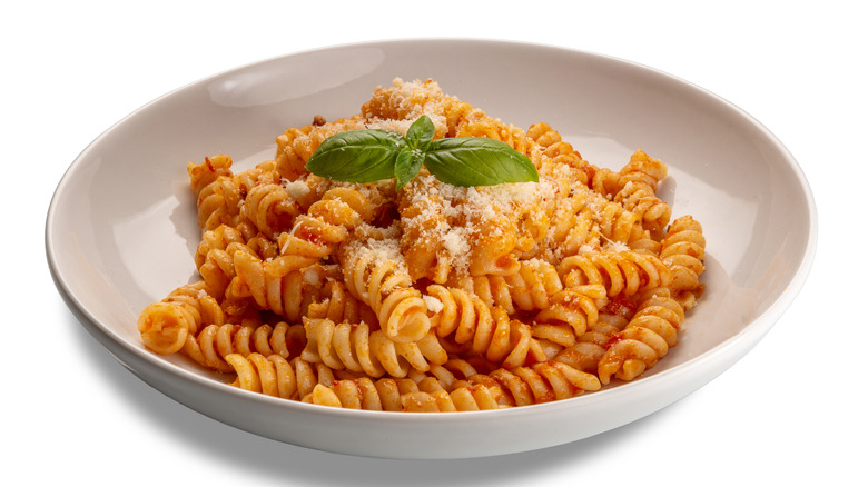 Fusilli tossed in tomato sauce on a plate