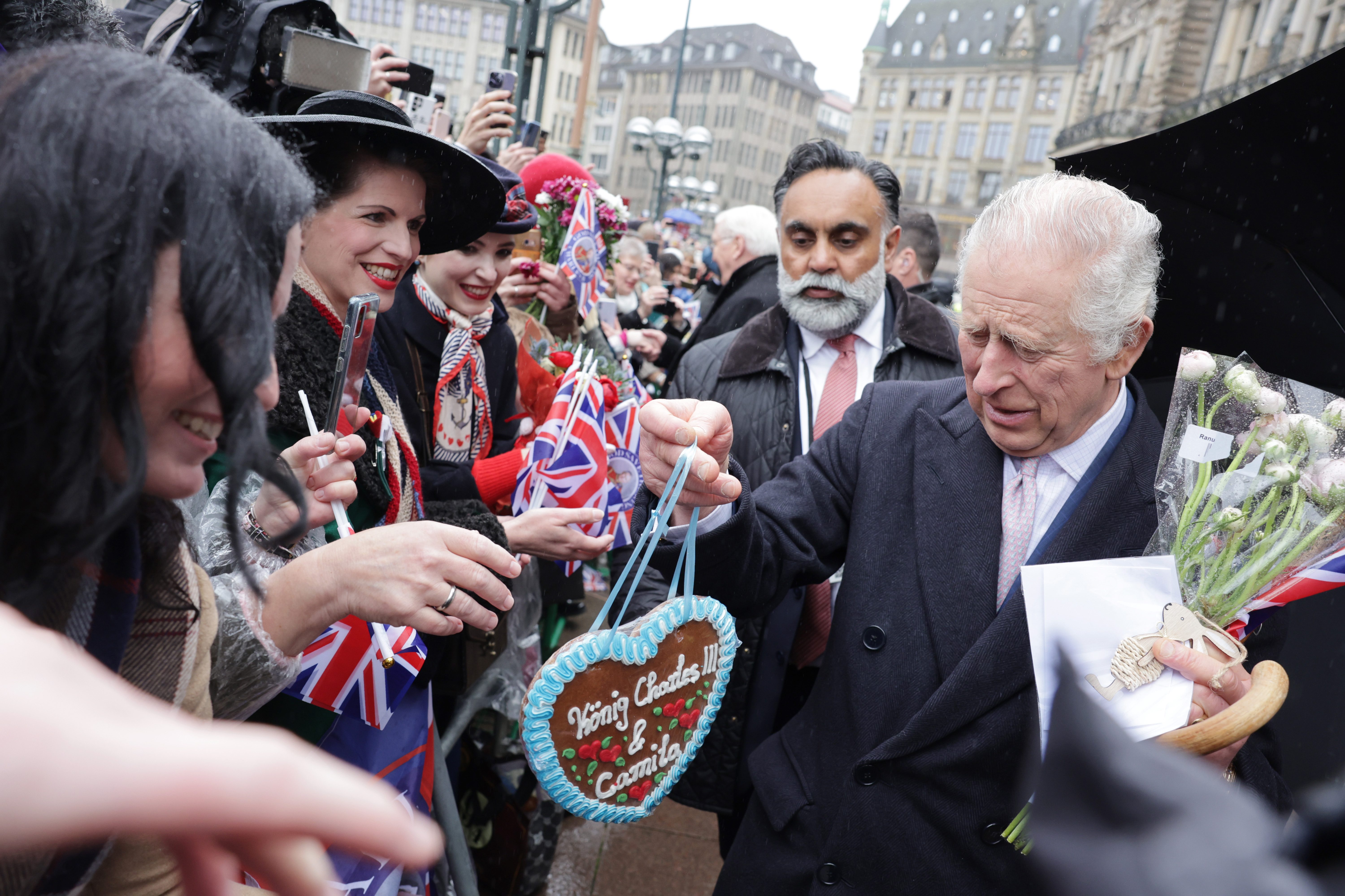 King Charles accepting a decorated cookie from fans in germany
