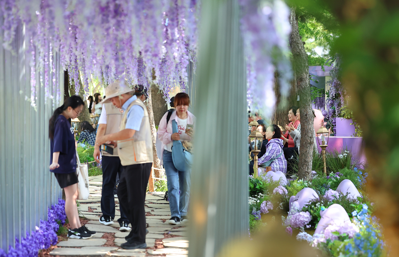 Visitors pass through a tunnel filled with purple flowers at the 2025 Seoul International Garden Show, which took place from May 22 to Nov. 2 at Boramae Park in Dongjak-gu, southern Seoul. (Yonhap)