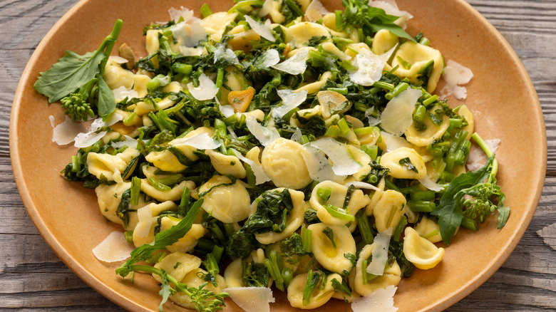 Orecchiette tossed with greens and parmesan on plate