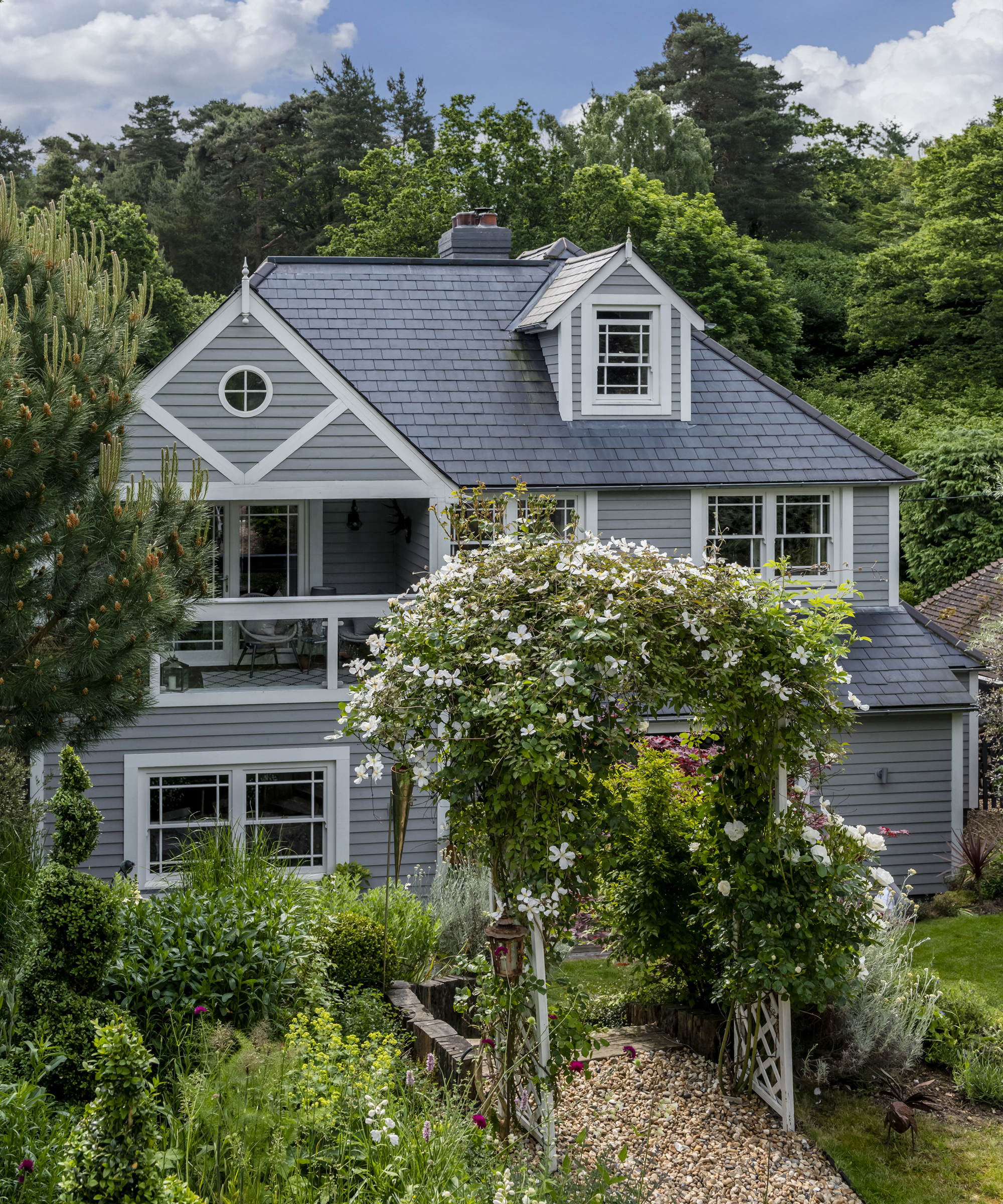 A stepped front garden with a rose arch over the pathway