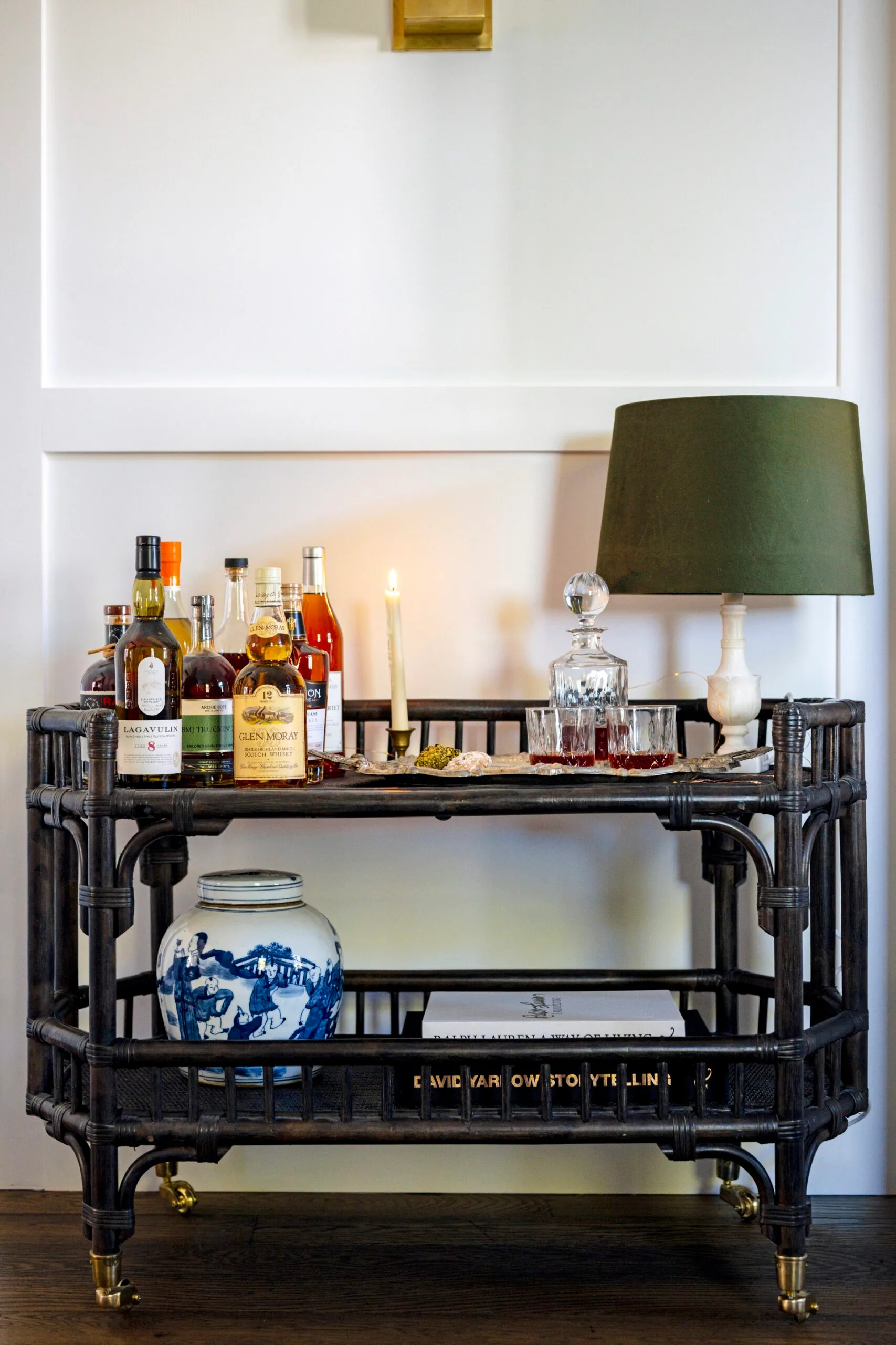 A black wicker bar cart with a lamp