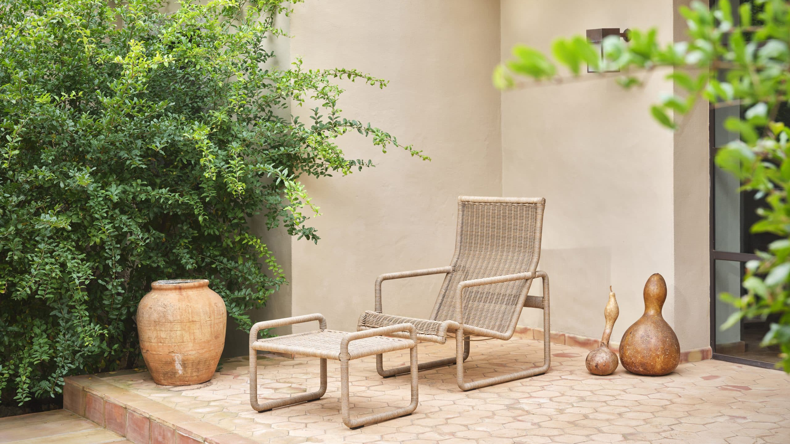 Munder Skiles Dessau Lounge Chair on a patio with a large terracotta pot.