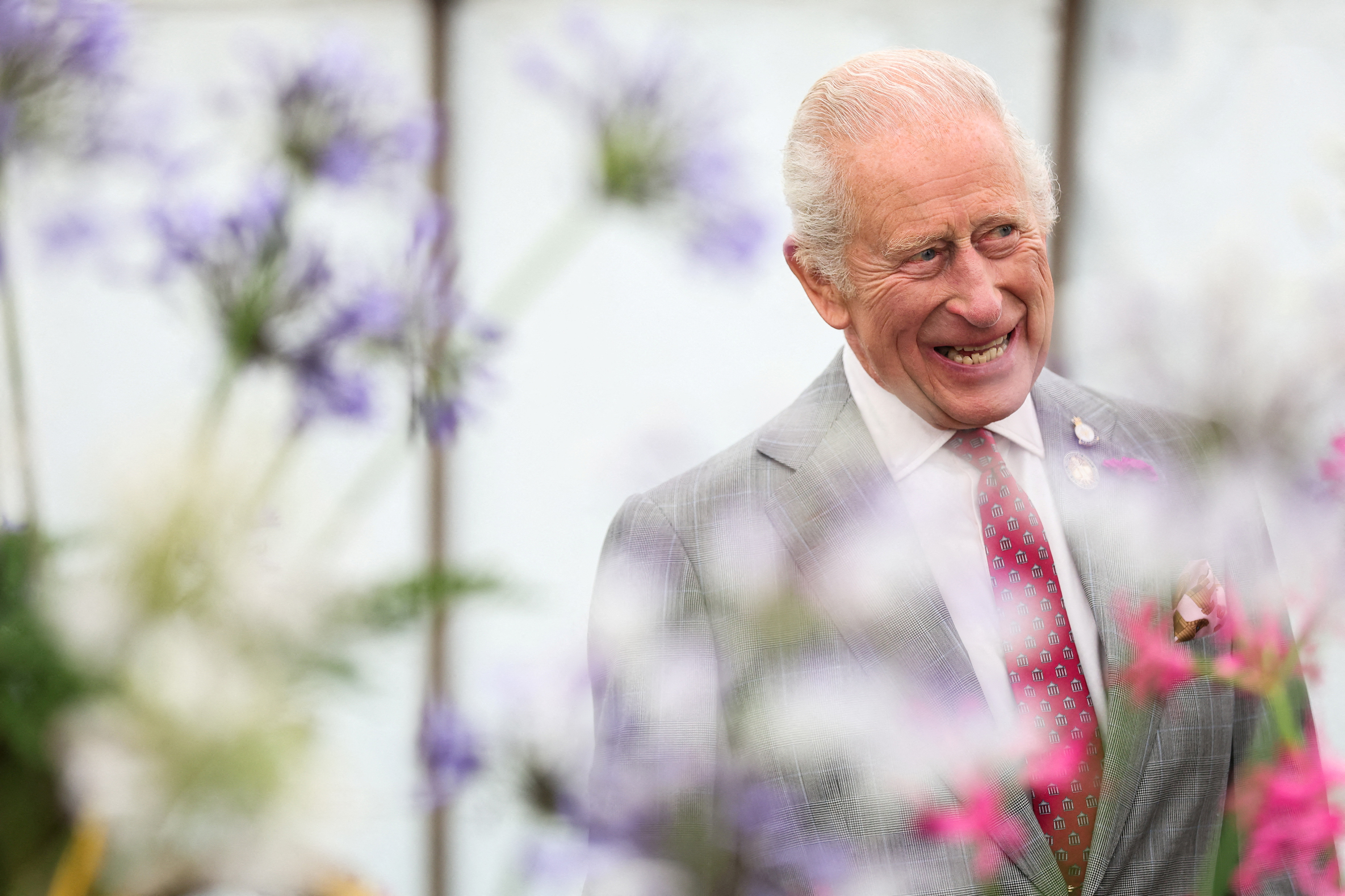 King Charles III smiling at the Sandringham Flower Show.