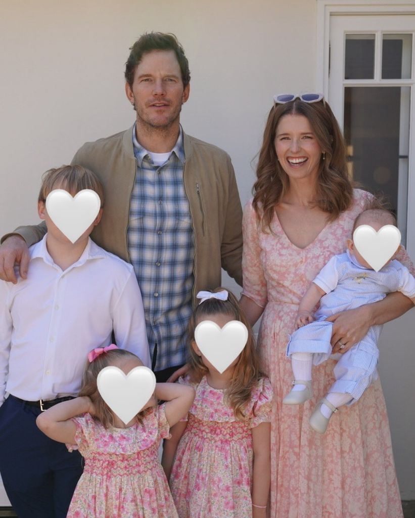 photo of chris pratt and katherine schwarzenegger smiling with all 4 kids who have white hearts covering their faces