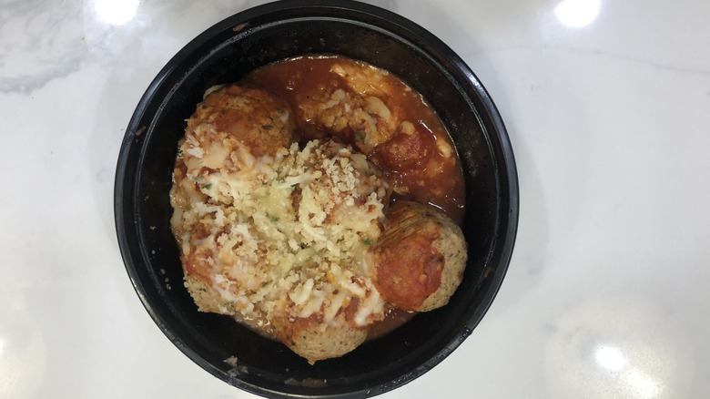 Olive Garden meatballs parmigiana in a to-go container.