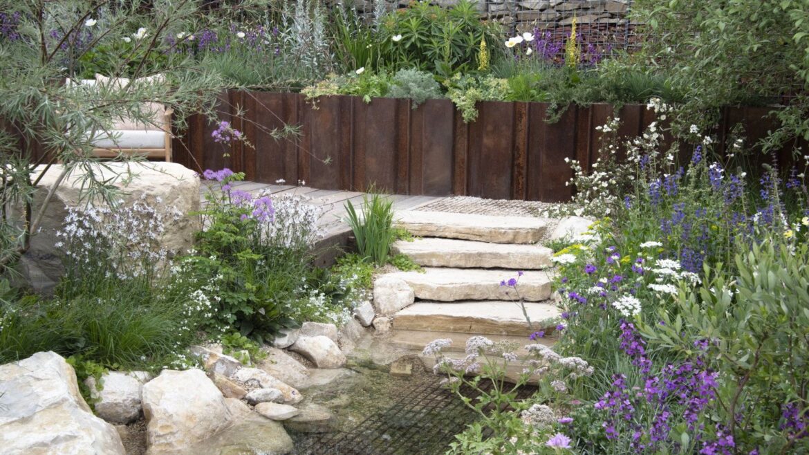 7 Key Overwintering Jobs to Do in December in Your Yard Flower beds surround a stone pathway, steps and a pond in a show garden