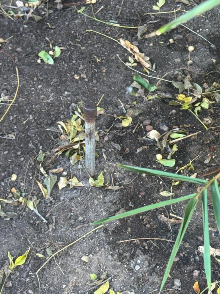 Help identifying metal stake in middle of backyard that connects across to a nail with a green flag