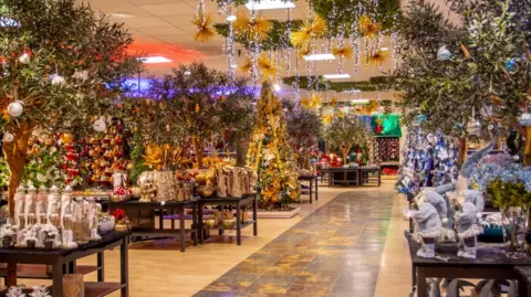 Blue Diamond The shopping area of Barton Grange Garden Centre showing tables of Christmas decorations and lights.