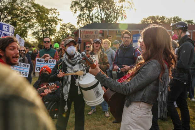 Joselyn Walsh, right, and other musicians play and sing in the protest area nea the U.S. Immigration and Customs Enforcement holding facility on Oct. 10, 2025, in Broadview. (Stacey Wescott/Chicago Tribune)