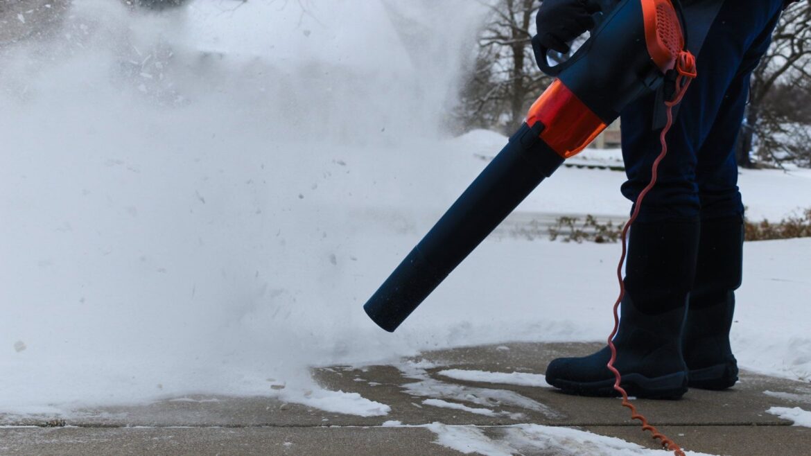 Can You Use a Leaf Blower for Snow? We Reveal the Answer A person is using a corded leaf blower to blow snow from their driveway