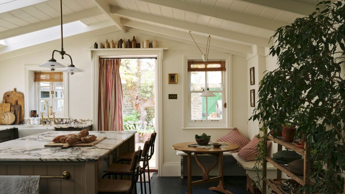 A Old Home’s New Kitchen Captures the English Countryside A new kitchen extension with vaulted paneled ceilings, olive green cabinets, marble countertops, and a cozy eat-in area