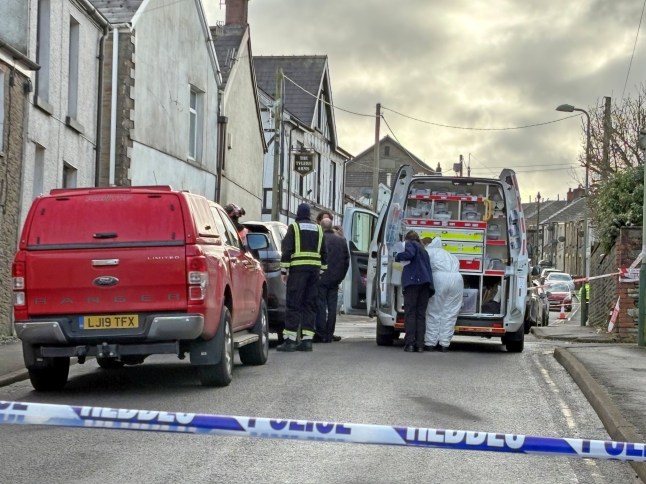 Emergency services at the scene in Heol Fawr, Nelson, where two people have died in a house fire following reports of an explosion in the garden, police said. Emergency services were called to the property in Caerphilly, south Wales.