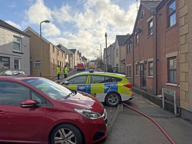 Emergency services at the scene in Heol Fawr, Nelson, where two people have died in a house fire following reports of an explosion in the garden, police said. Emergency services were called to the property in Caerphilly, south Wales, at 6.10pm on Friday.