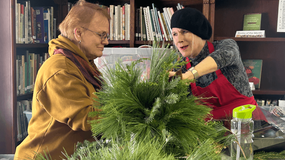 A pair of women can be seen collaborating on a festive arrangement for the upcoming 72nd annual Holiday Greens Sale.{ } The event doubles as a fundraiser for local scholarships, and charitable purposes in the art of gardening and landscaping. (Teanna Barnes/WWMT){p}{/p}