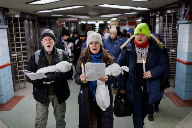 Dave Martin, from left, Joselyn Walsh and Joseph Ozment sing pro-Palestinian carols with other activists near the State/Lake CTA station, Dec. 14, 2025, in Chicago. In October, a federal grand jury indicted six people, one of whom was Walsh, on conspiracy charges stemming from an immigration protest outside the Broadview Immigration and Customs Enforcement facility. (Armando L. Sanchez/Chicago Tribune)