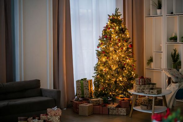 Decorated Christmas tree with glowing lights and gift box under it in living room. Decorated Christmas tree with glowing lights and gift box under it in living room.