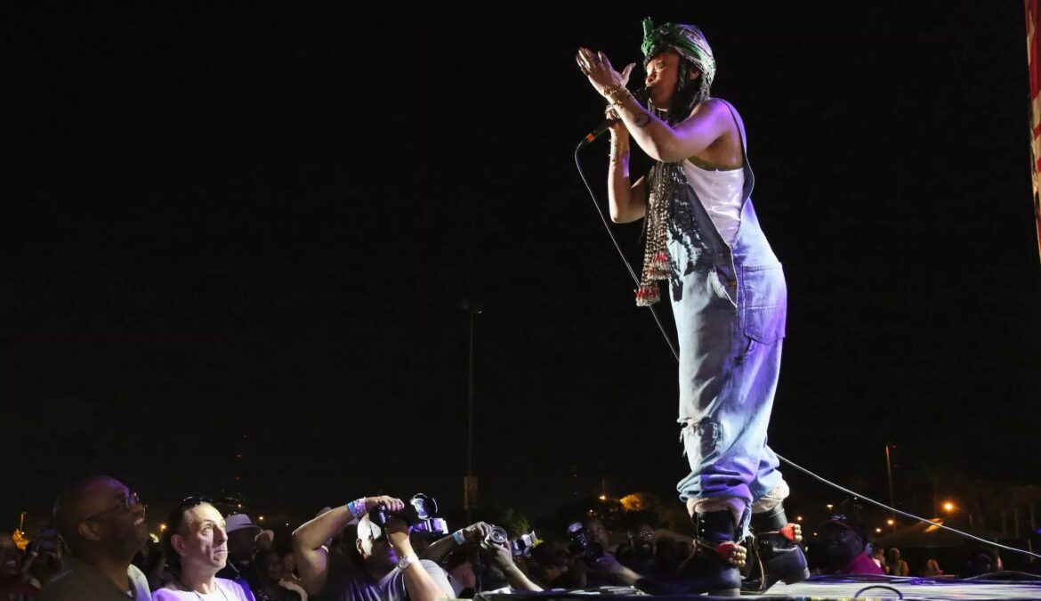 A woman on stage singing holding a mic.