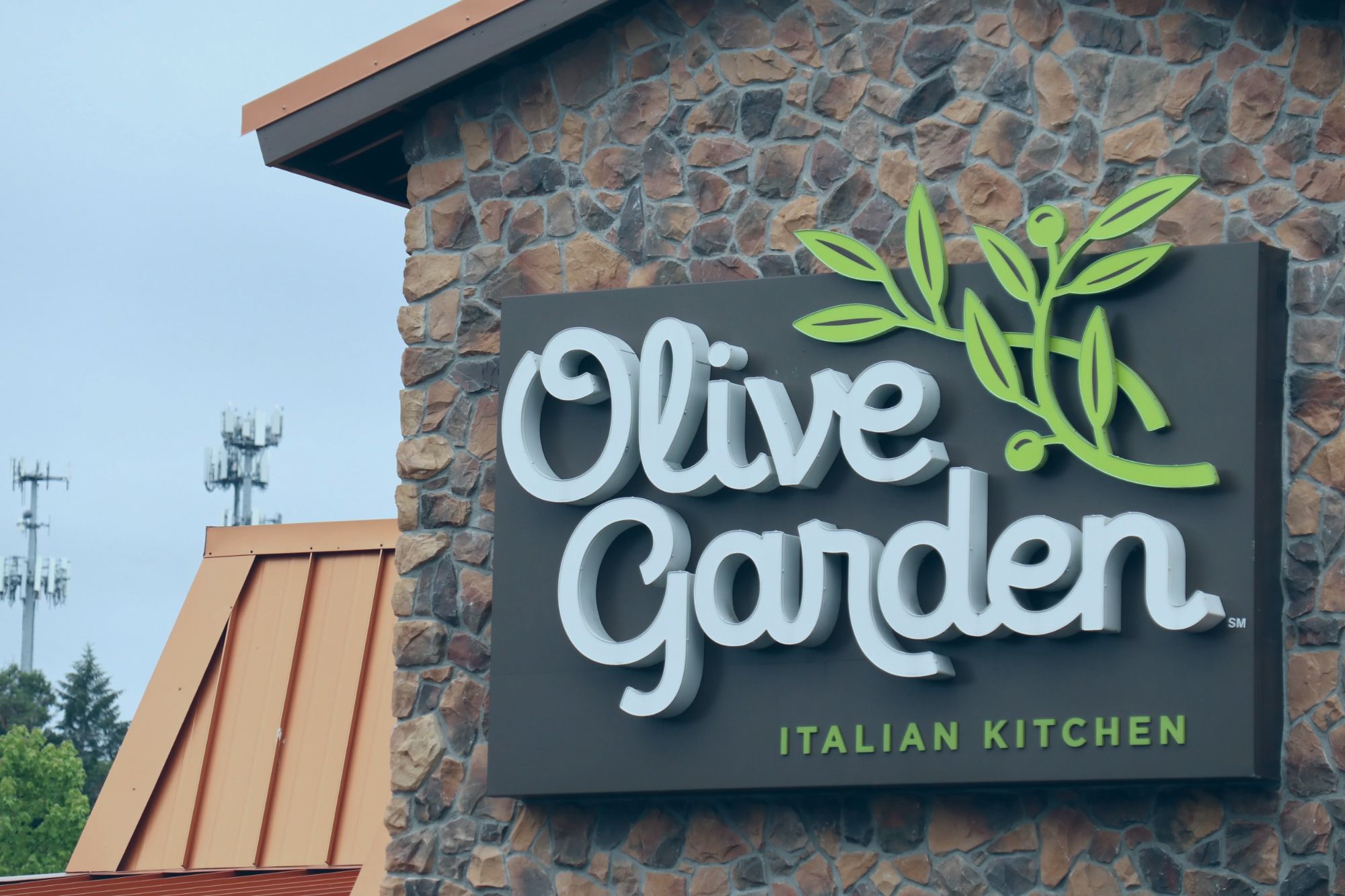 An image collage containing 1 images, Image 1 shows An Olive Garden Italian Kitchen sign on a stone wall