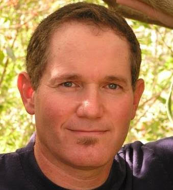 Headshot of male with brown hair and navy top