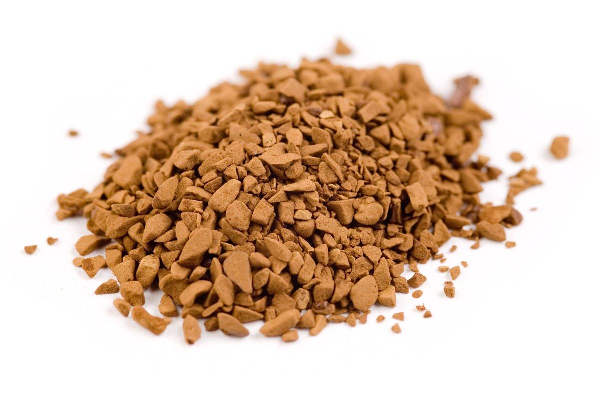 A heap of finely ground brown powder rests on a pristine white surface, suggesting a substance possibly used in culinary or herbal applications.
