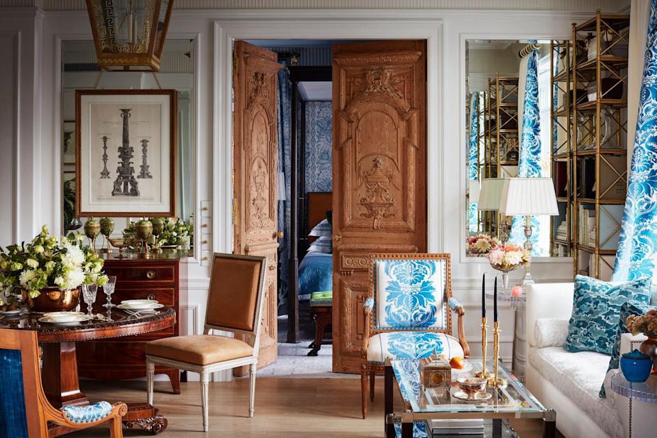 living area with ornate wood doors leading to bedroom