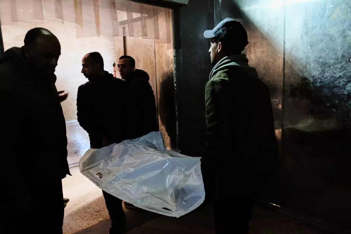 Relatives carry the bodies of members of the Al-Atbash family, who were killed in an Israeli military strike, at Shifa Hospital in Gaza City Saturday, Jan. 31, 2026. (AP Photo/Jehad Alshrafi)
