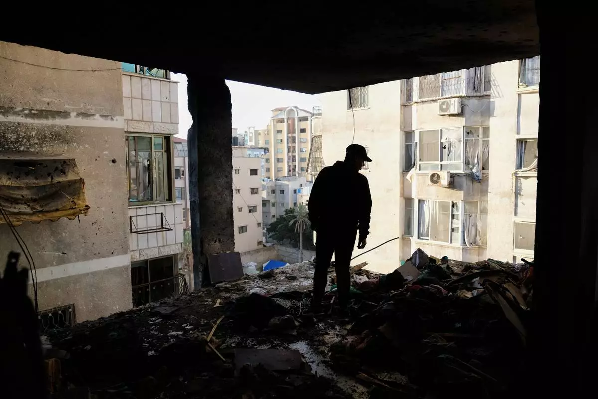 A Palestinian man surveys the damage to an apartment building after an Israeli military strike killed several people in Gaza City Saturday, Jan. 31, 2026. (AP Photo/Jehad Alshrafi)