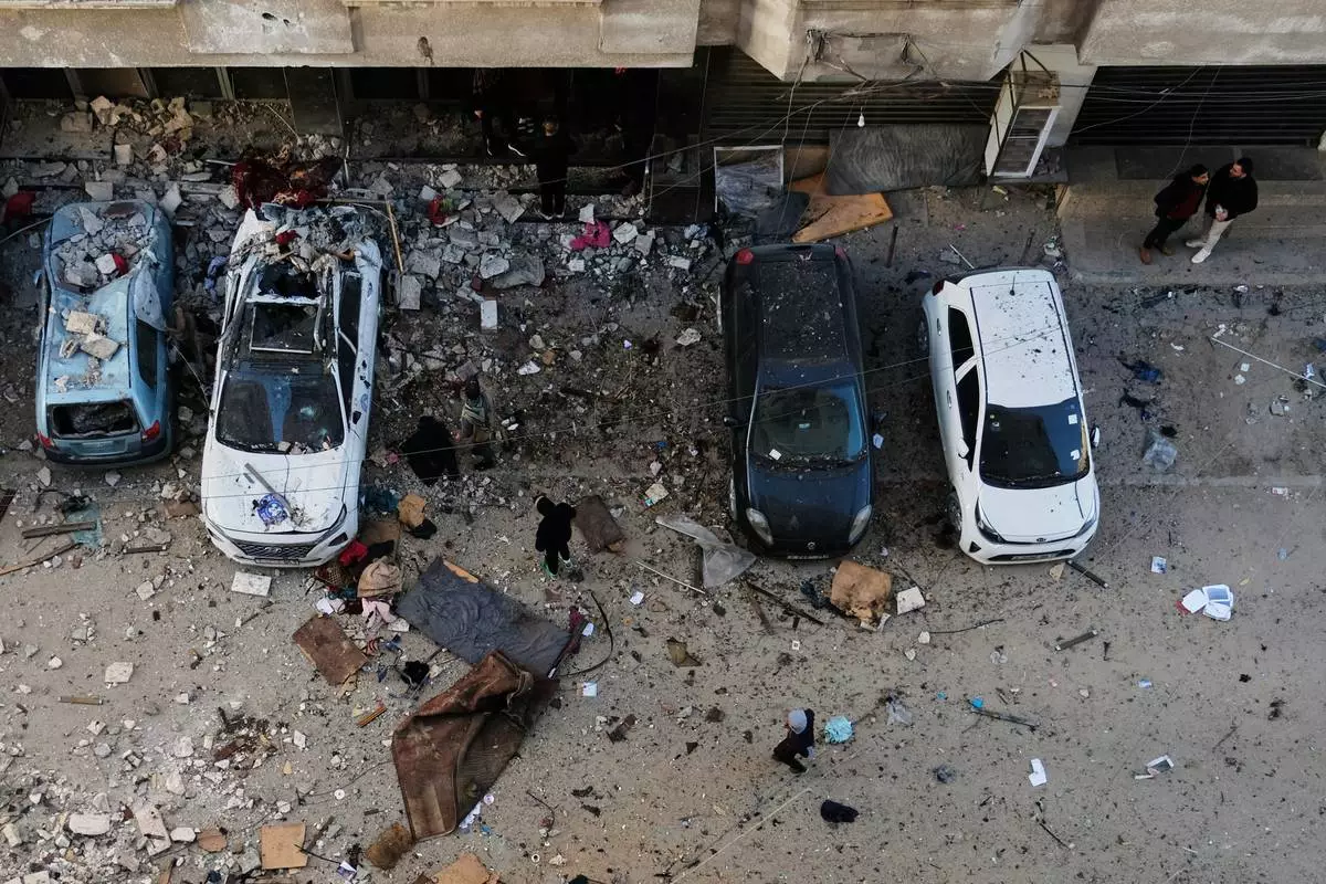 Palestinians survey the damage to an apartment building after an Israeli military strike killed several people in Gaza City Saturday, Jan. 31, 2026. (AP Photo/Jehad Alshrafi)