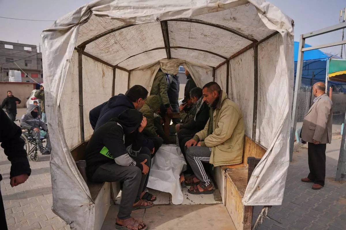 Palestinians mourn over the body of a person who was killed in an Israeli strike, as they sit on a cart during his funeral outside at Al-Aqsa Hospital in Deir al-Balah, central Gaza Strip, Friday, Jan. 30, 2026. (AP Photo/Abdel Kareem Hana)