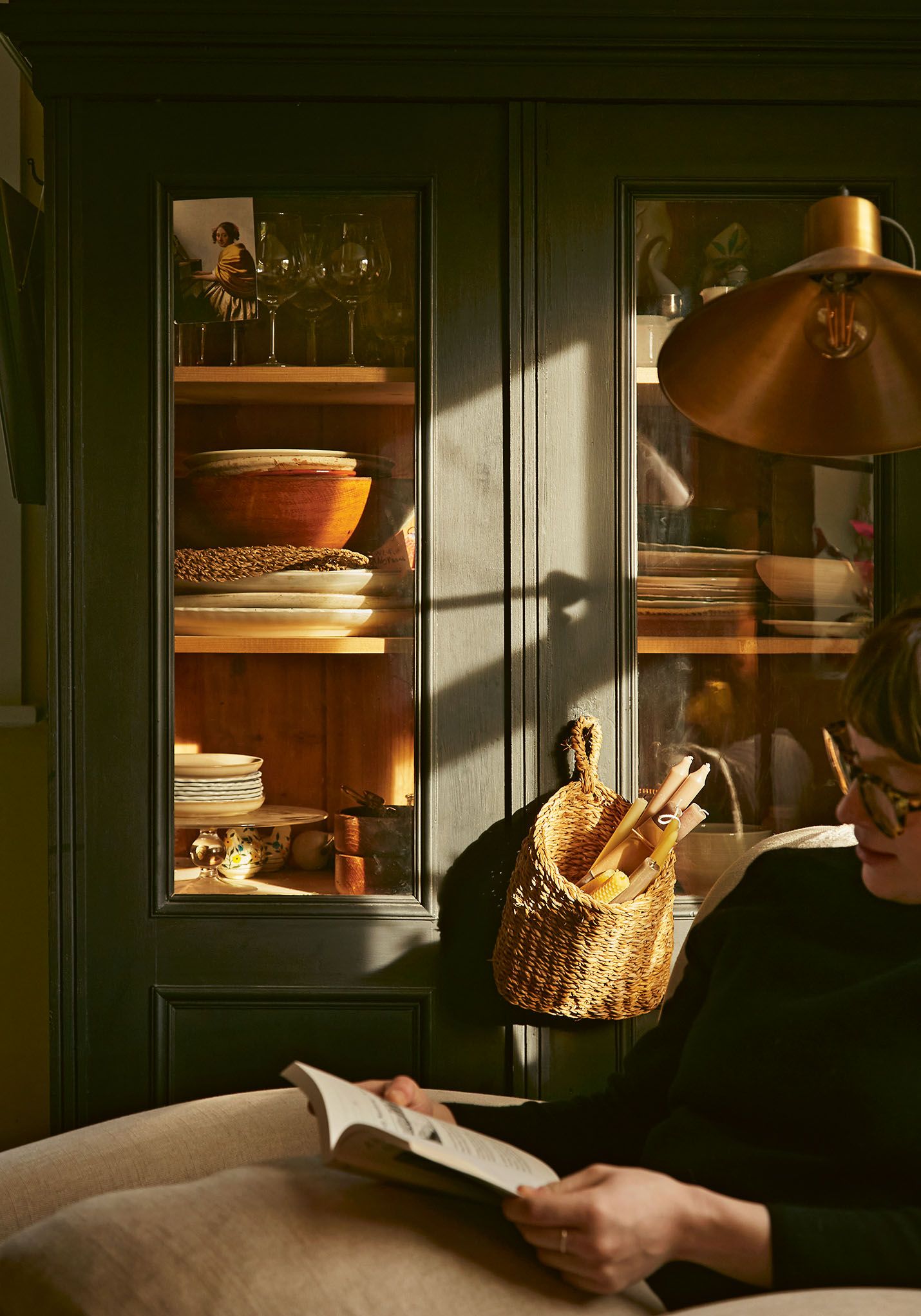 Image may contain Person Reading Furniture Cabinet Shelf Face Head and Lamp