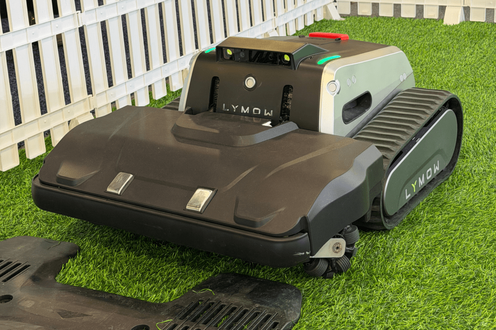 Lymow robotic lawnmower with tracks on artificial grass.