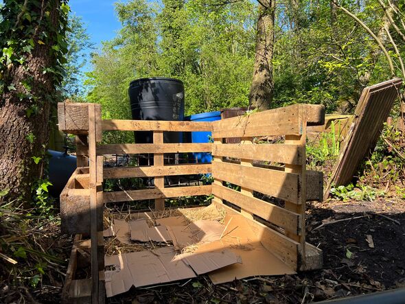 Three wooden pallets are connected to create a compost heap. Cardboard on the ground to attract and feed the worms. Three wooden pallets are connected to create a compost heap. Cardboard on the ground to attract and feed the worms.
