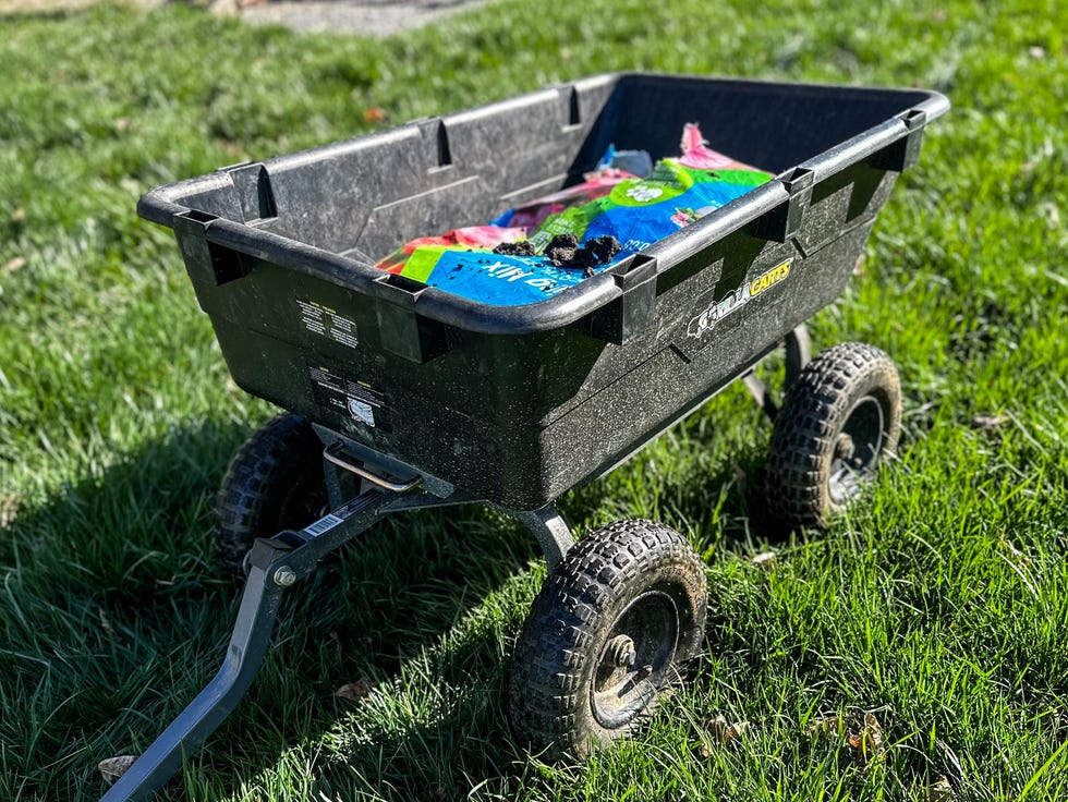 gorilla carts poly garden dump cart filled with bags on green grass