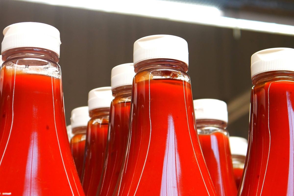 Many beautiful bottles of ketchup on a supermarket shelf close-up. 