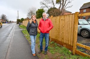 Ian and Bethany Buswell pictured in front of their new fence - which they have been ordered to take down - at their home in Hallow in Worcester.