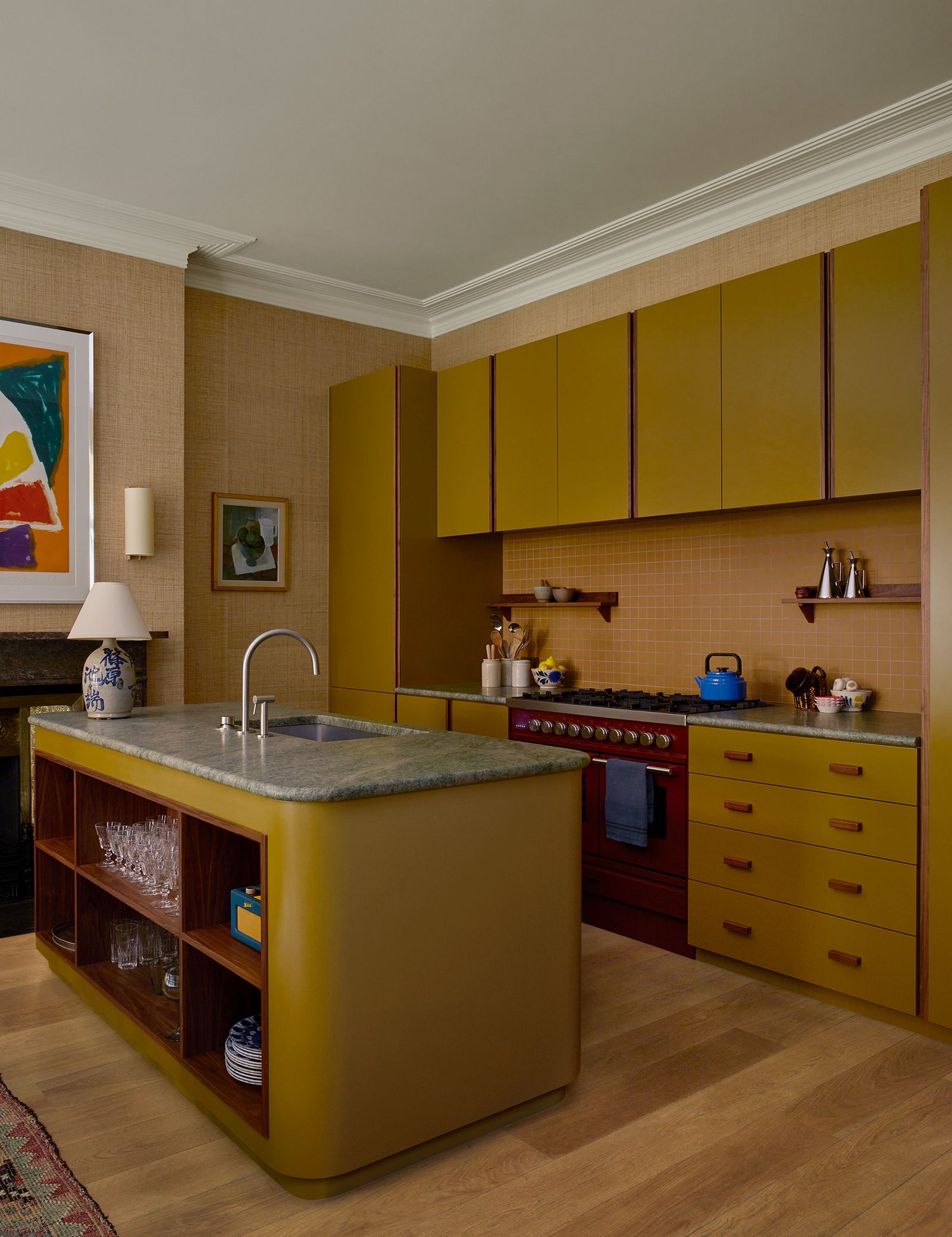 Walnut details and curved corners bring softness to the joinery in the kitchen of Brandon Schuberts north London...