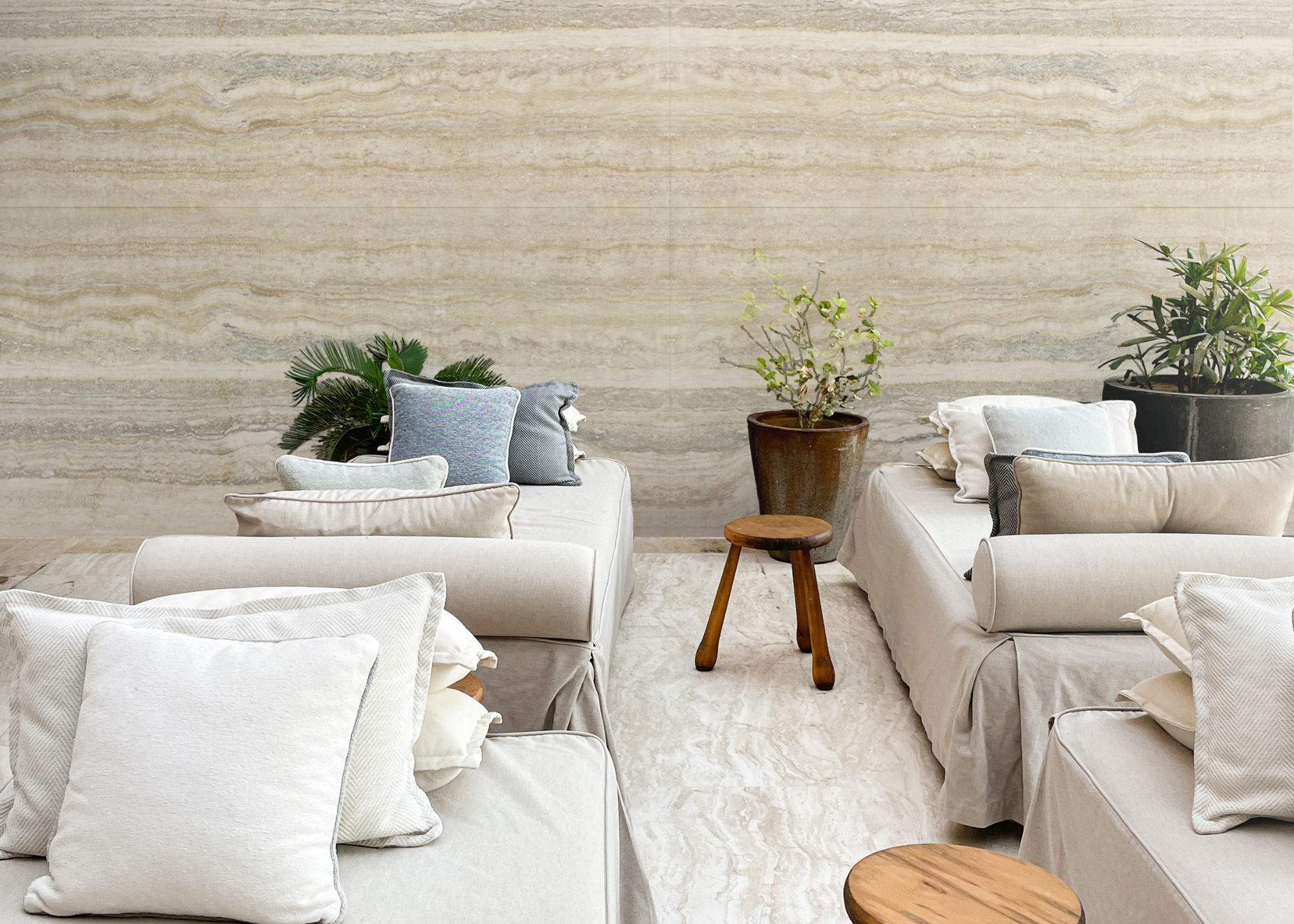 travertine seating area with potted plants and low sofas