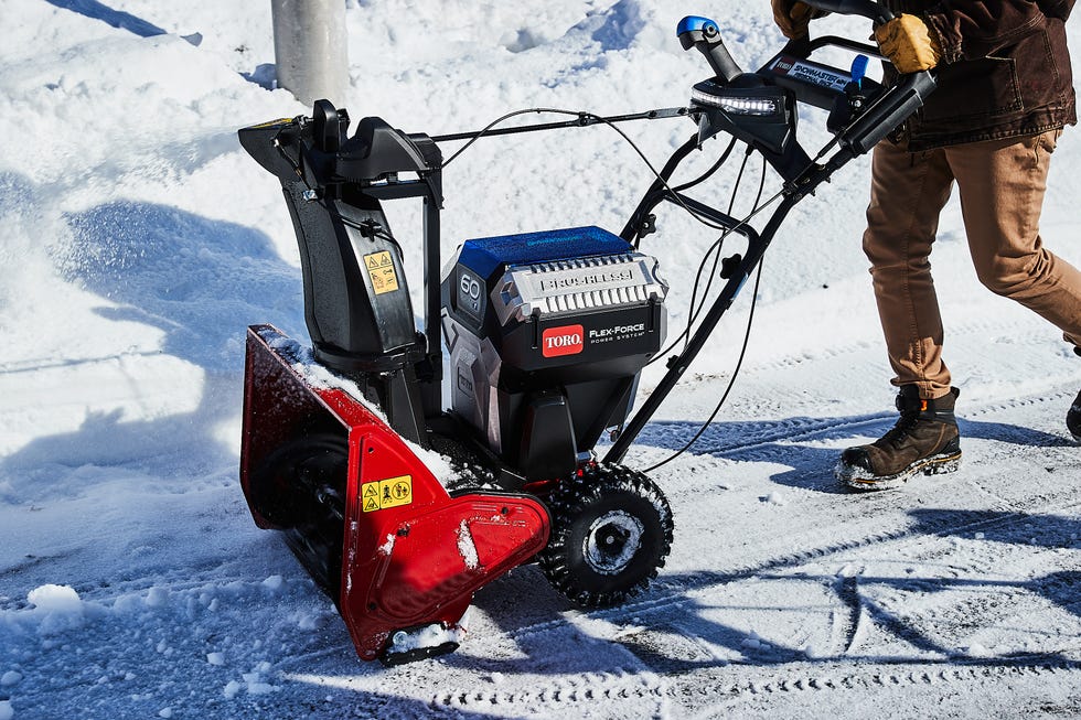 Electric snowblower being used to clear snow from a pathway.